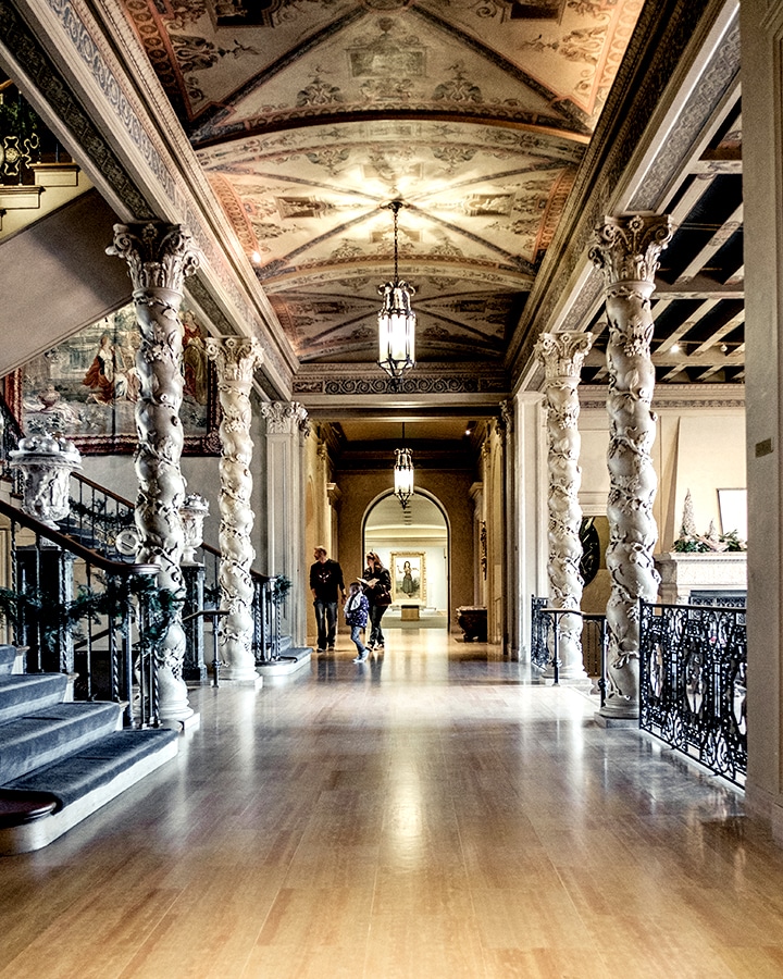 People walking through a large and ornate hallway