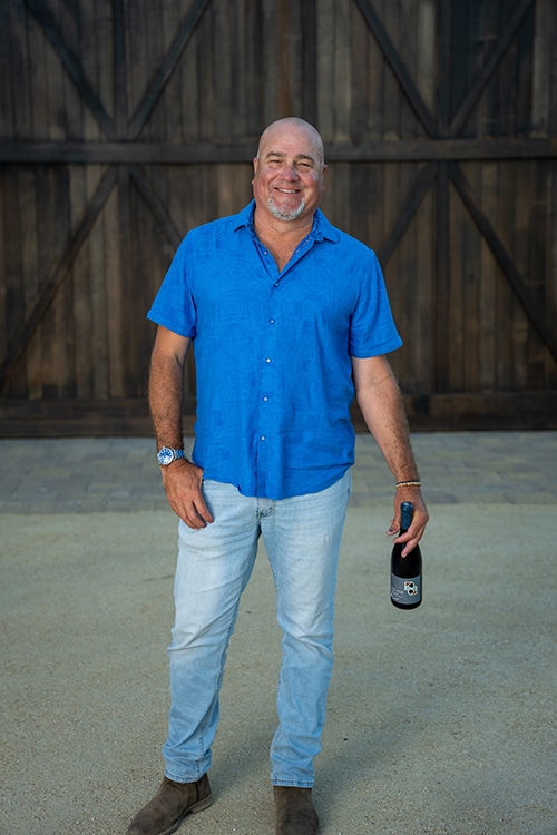 Dan Kosta holding a bottle of wine
