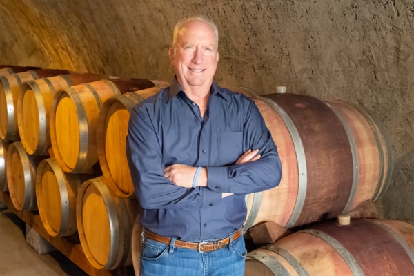2023 SCWA Vintner Honoree Stuart Bryan standing in front of stacked wine barrels